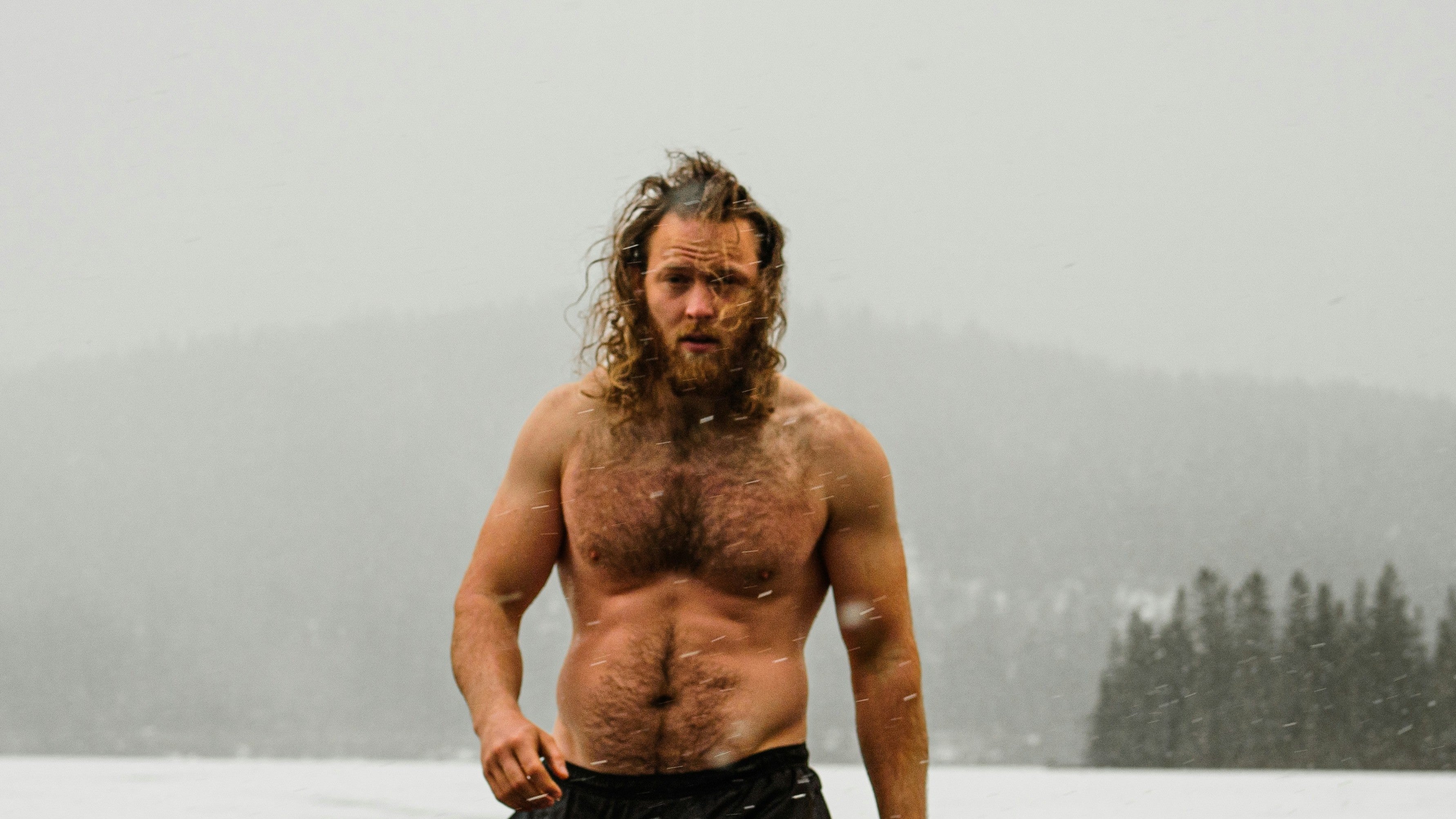 Starker Man läuft aus dem See im Winter
